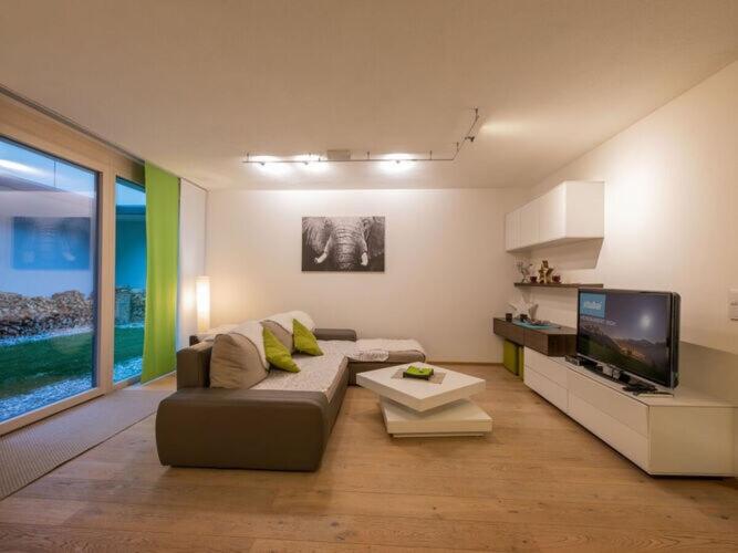 sala de estar con sofá y TV de pantalla plana en Tasteful apartment in Fulpmes, en Fulpmes