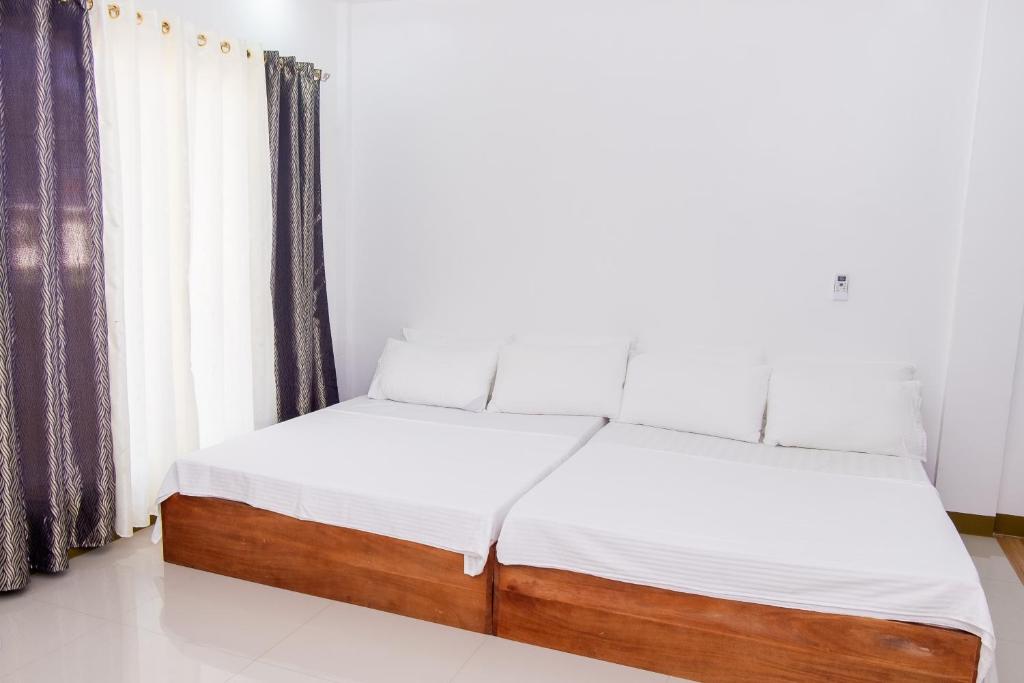 2 camas individuais num quarto com uma janela em E and c tourist inn em Dumaguete