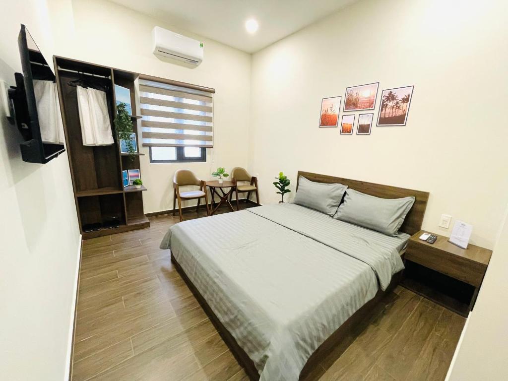 1 dormitorio con 1 cama grande y 1 mesa en Rio Guest House - Phú Quốc en Phu Quoc