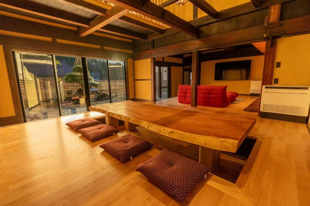 須田貝にある藤左ヱ門の宿の木製テーブルと椅子が備わる広い客室です。