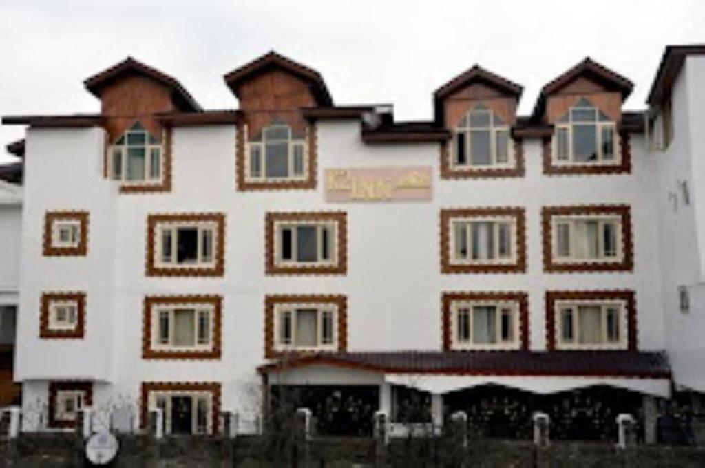 ein großes weißes Gebäude mit braunen und weißen Fenstern in der Unterkunft HOTEL K2 INN , Srinagar in Srinagar