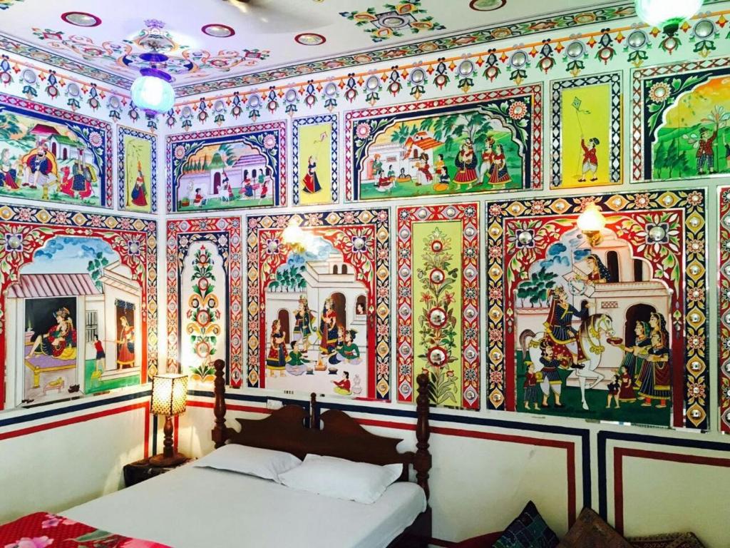 a bedroom with a wall covered in christmas decorations at HOTEL SHEKHAWATI HAVELI in Mandāwa