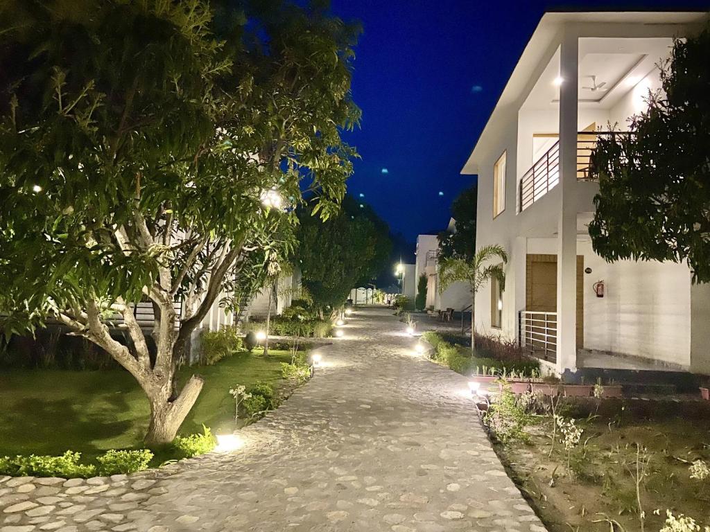 a street at night with a tree and a building at The White Oak Corbett Spa & Resort in Rāmnagar