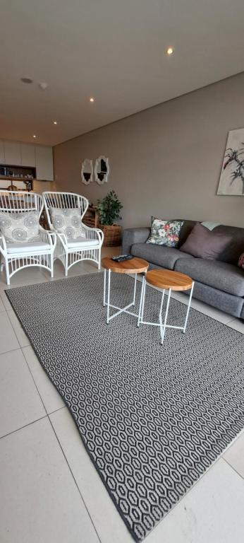 een woonkamer met witte meubels en een tapijt bij Zimbali Suites 505 in Ballito