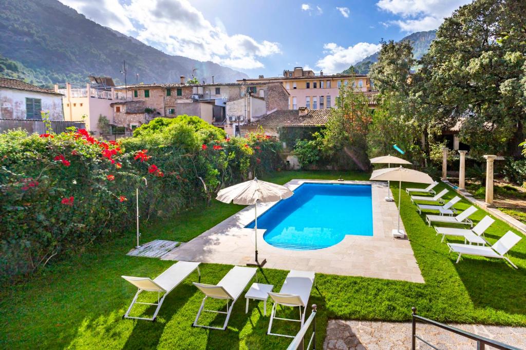 Una piscina con sillas y sombrillas en un patio. en EN PATI DE SOLLER, en Sóller