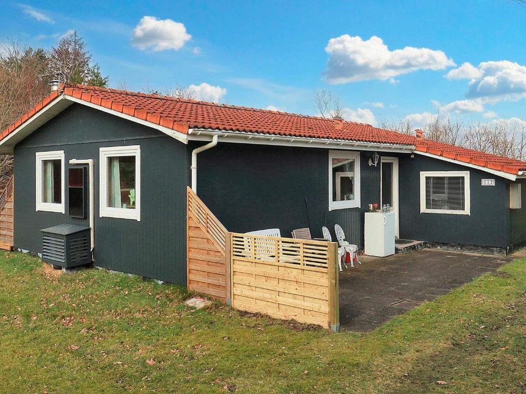 a blue house with a porch and a yard at 5 person holiday home in Asaa-By Traum in Aså