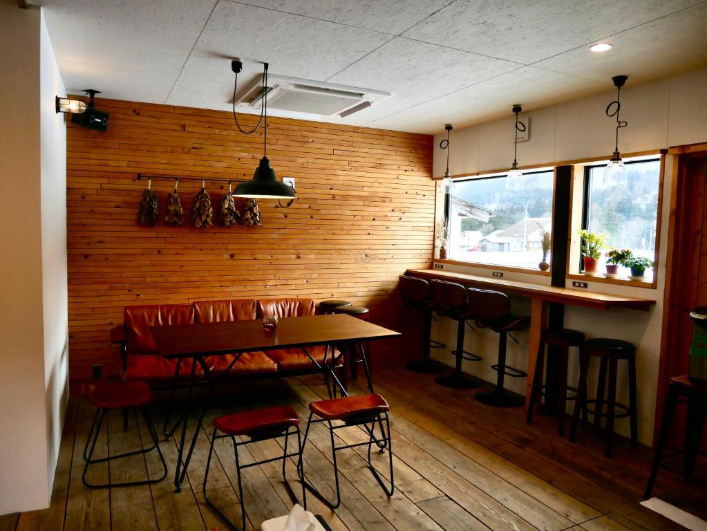 白川村にあるGuestHouse Shirakawa-Go INNのテーブルと椅子のあるレストラン、バー