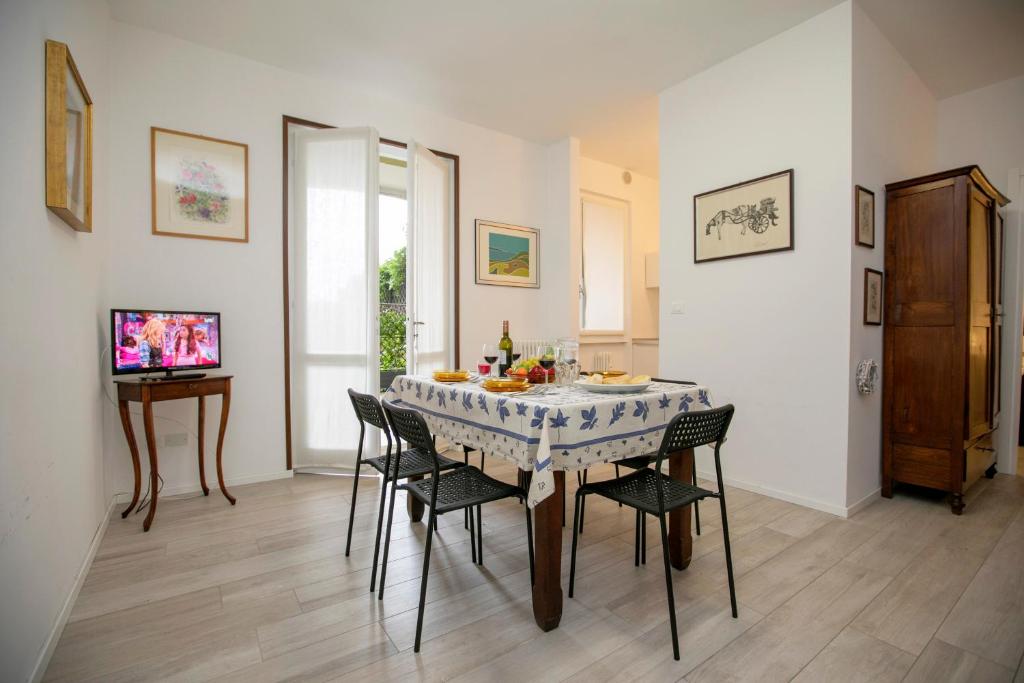 comedor con mesa con sillas y TV en Casa Del Lago - Happy Rentals, en Desenzano del Garda