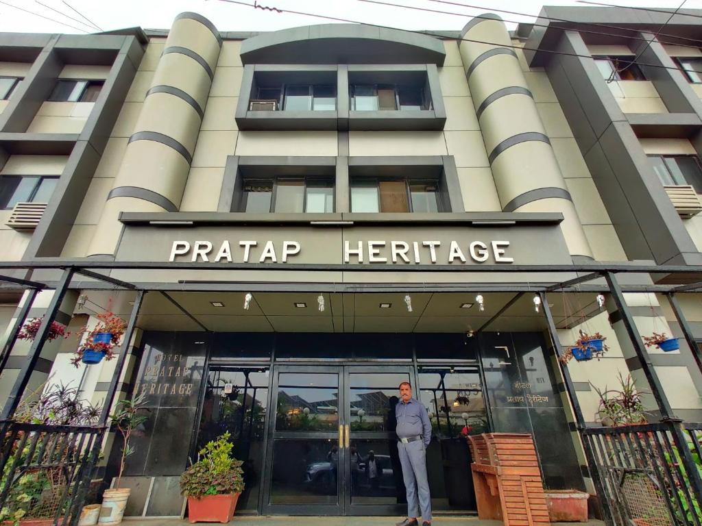 a man standing in front of a building at Hotel Pratap Heritage in Mahabaleshwar