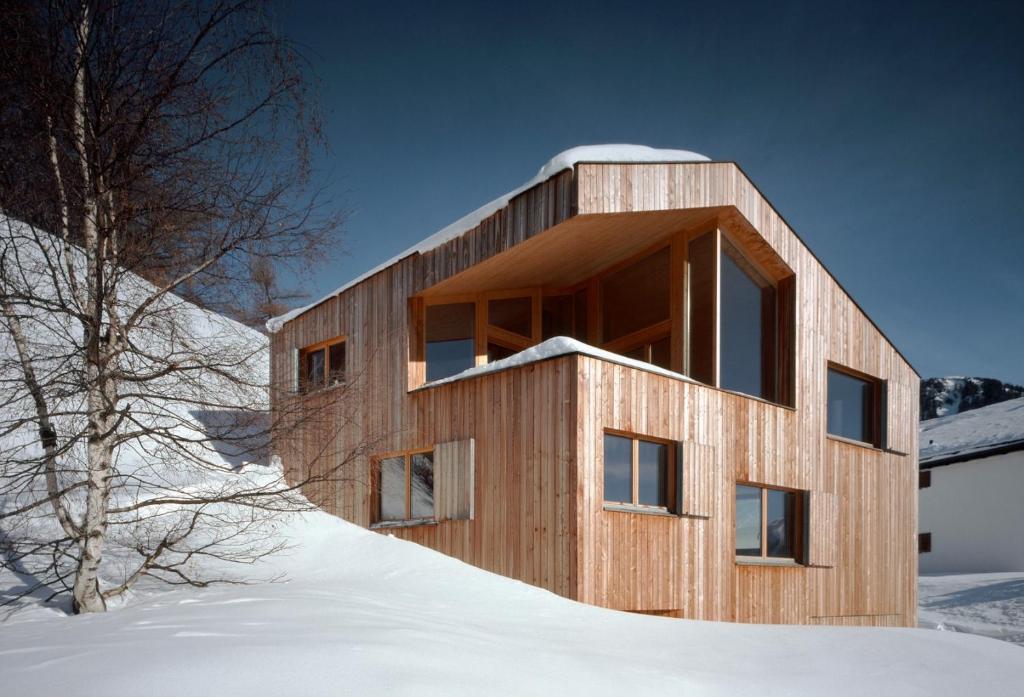 ein Holzhaus auf einem Hügel im Schnee in der Unterkunft vittu in Langnau am Albis