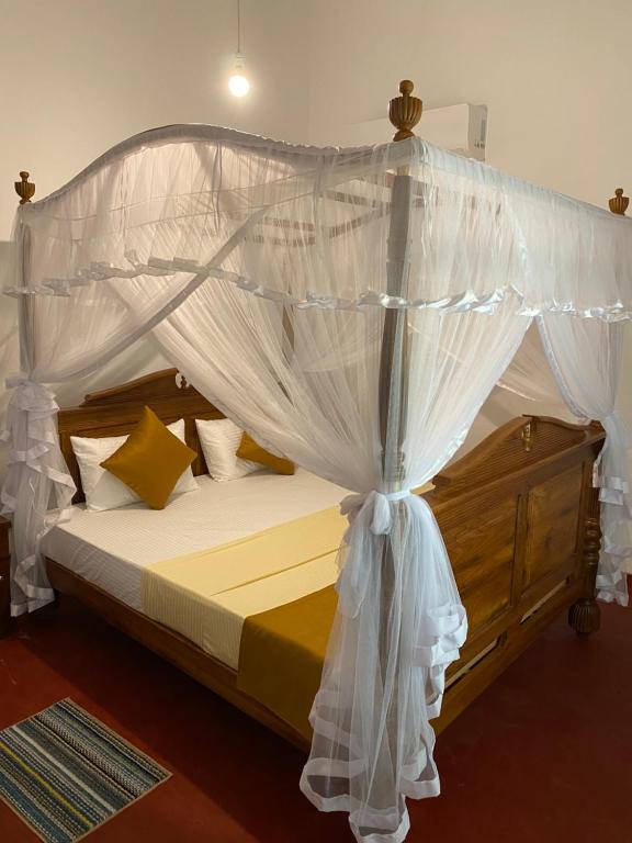 a bedroom with a canopy bed with white curtains at 682 Villa Weligama in Weligama