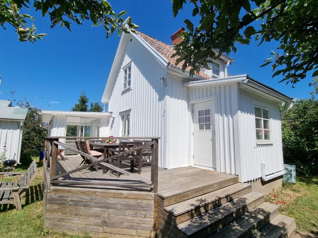 Casa blanca con terraza y mesa en Hus i Algutsrum, en Färjestaden