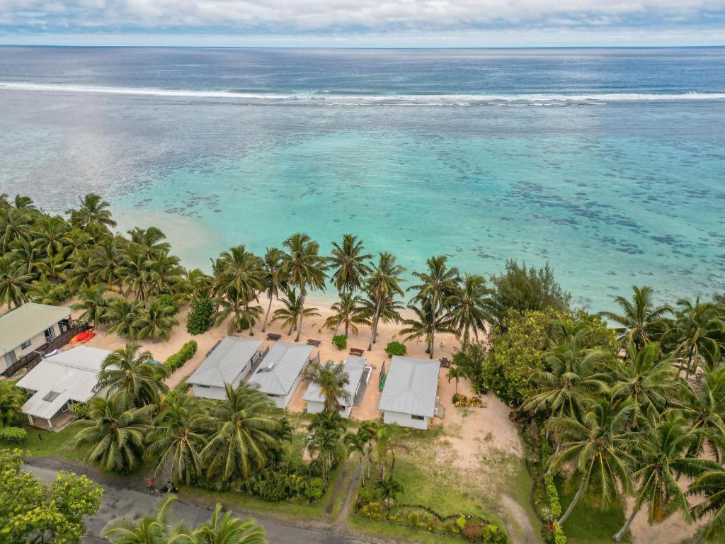 an aerial view of a beach with palm trees and the ocean at Bella Beach Bungalows in Rarotonga