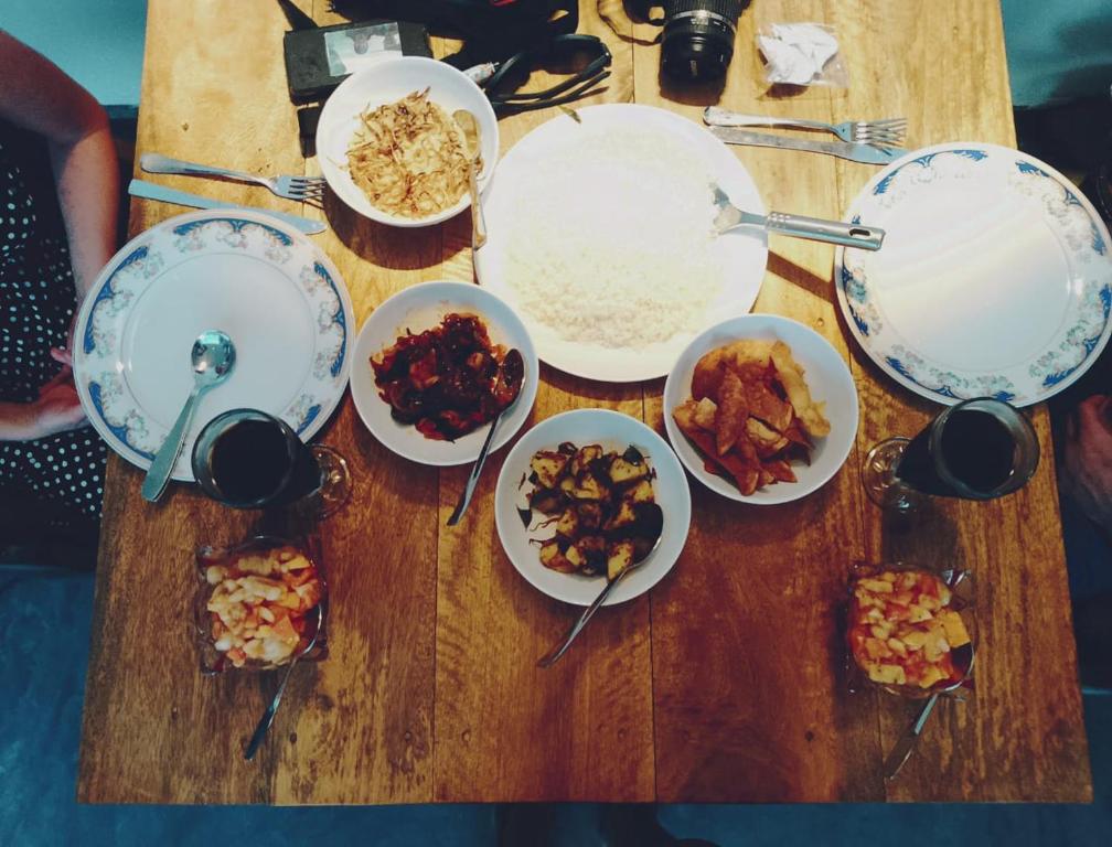 una mesa de madera cubierta con tazones y platos de comida en Villa kandupamula, en Mirissa