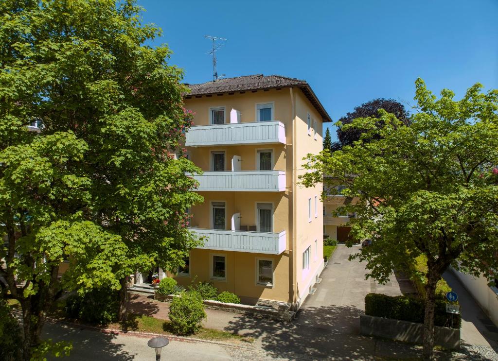 un edificio de apartamentos con árboles delante de él en Hotel Marienhof, en Bad Wörishofen