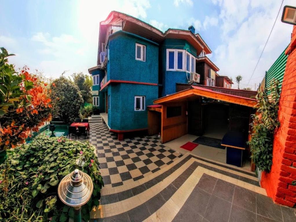 斯利那加的住宿－Nigeen Residency Resort , Srinagar，院子里的蓝色房子,有格子地板