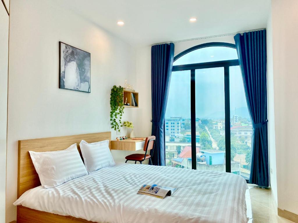 um quarto com uma cama e uma grande janela em Hola City Apartment 