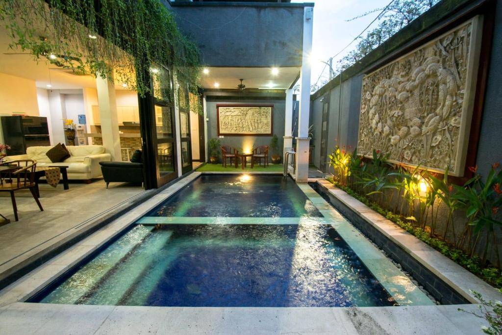 a swimming pool in the middle of a house at Villa cinta buana 1 in Legian