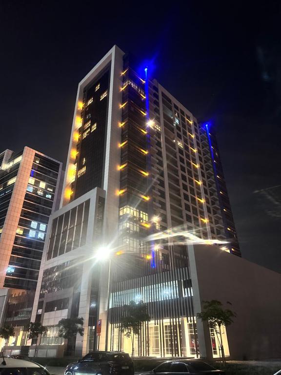 a tall building with blue lights on it at night at Shared Private Room in Downtown Business Bay in Dubai