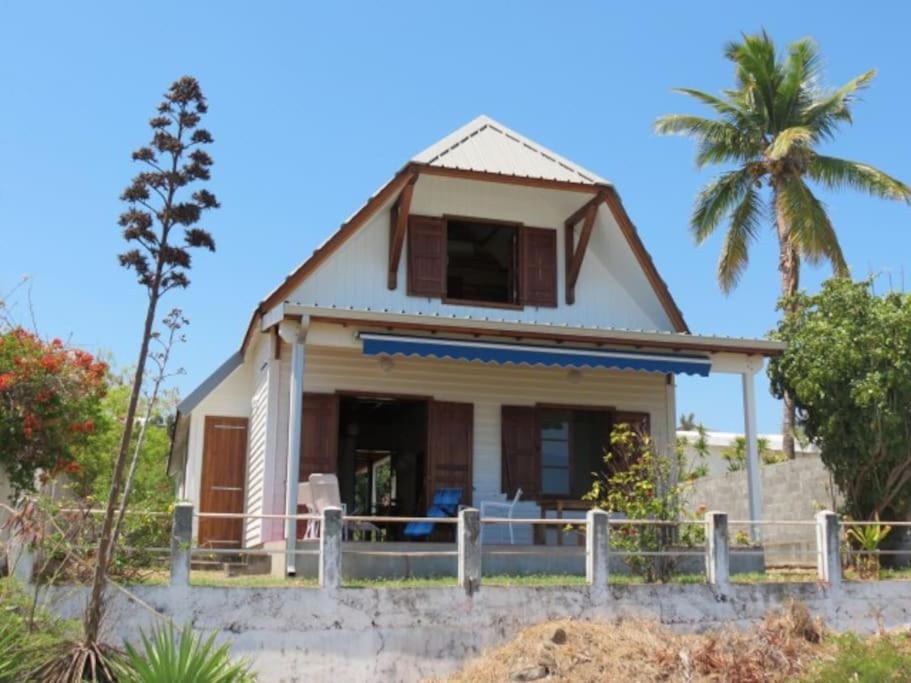 una casa en la playa con una palmera en Villa Joséphine sur la plage, en Saint-Paul