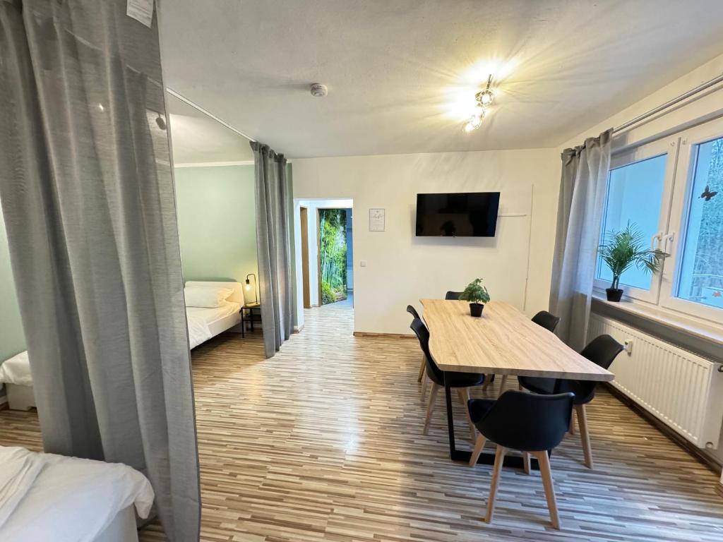 a room with a table and chairs and a bed at A05 - Wohnung für 6 Pers - 3 Zi mit Balkon inkl smart TV in Bad Homburg vor der Höhe