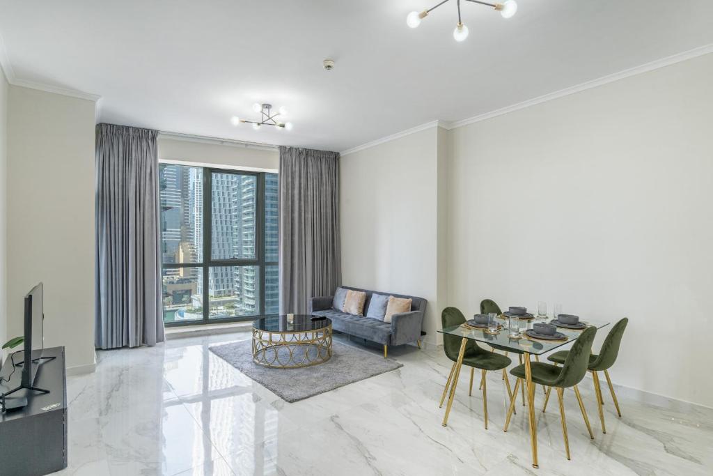 een woonkamer met een tafel en stoelen en een bank bij Torch Tower,Dubai Marina - 1BR Apartment - Allsopp&Allsopp in Dubai