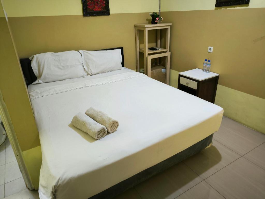 una camera da letto con un grande letto con asciugamani di PROMOSIA GUEST HOUSE a Surabaya