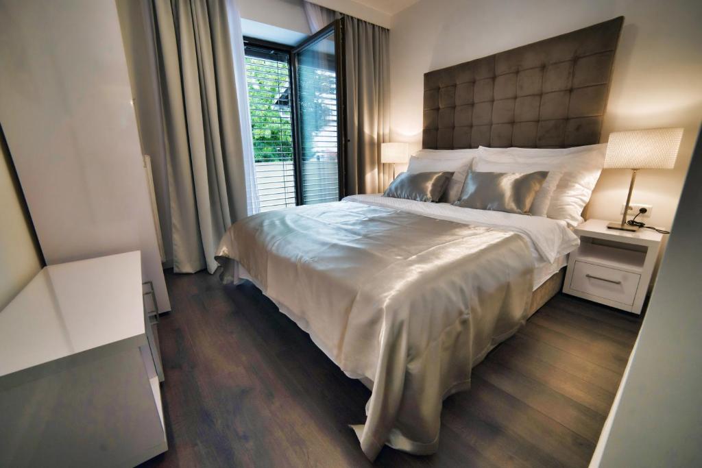 sypialnia z dużym łóżkiem i oknem w obiekcie Casa V Luxury Apartments w Zagrzebiu