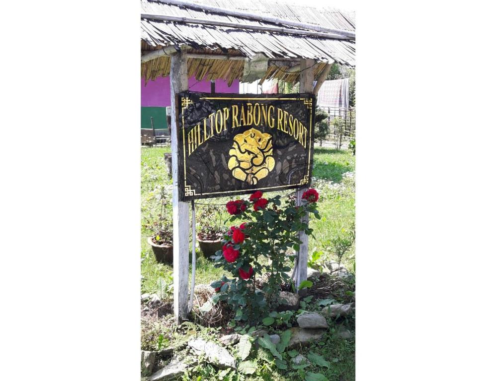 um sinal para o jardim de uma planta com flor em Hilltop Rabong Resort, Sikkim em Ravangla