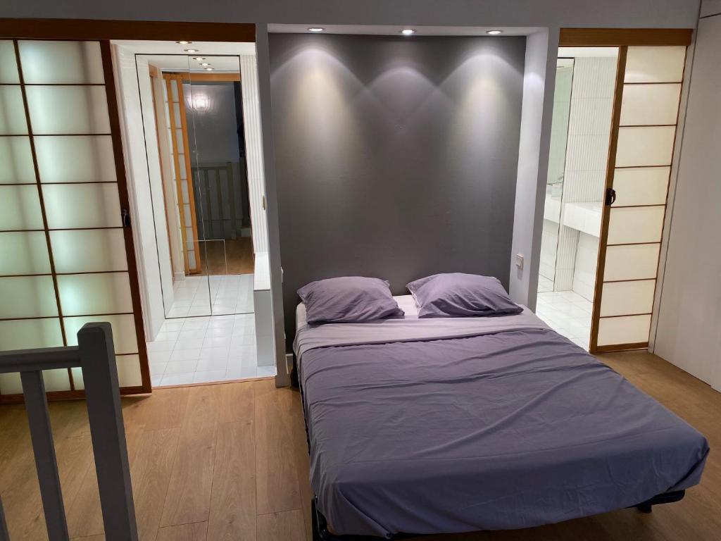 - un lit avec des draps violets dans l'établissement Beautiful 1-Bed Duplex Apartment in Beziers City, à Béziers