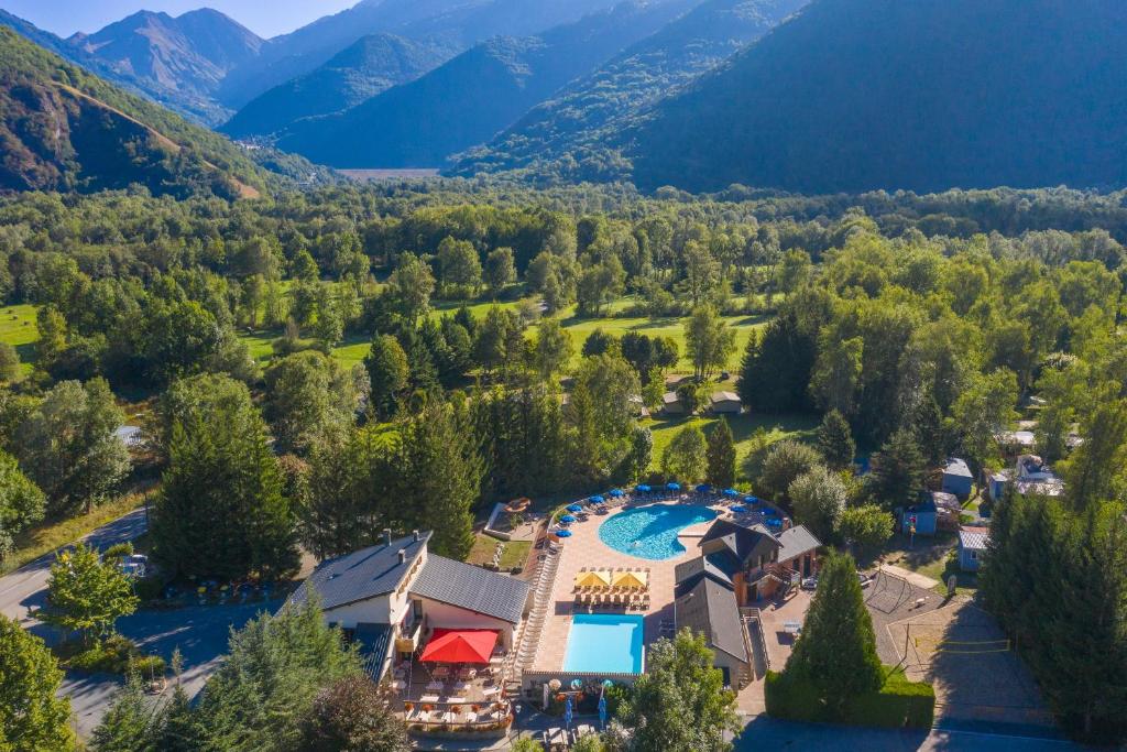 uma vista aérea de um resort com uma piscina e montanhas em Camping RCN Belledonne em Le Bourg-dʼOisans