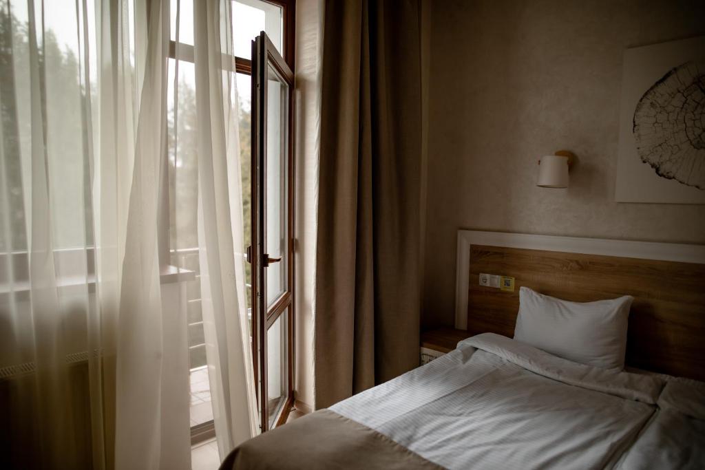 um quarto com uma cama ao lado de uma janela em Helios em Bukovel