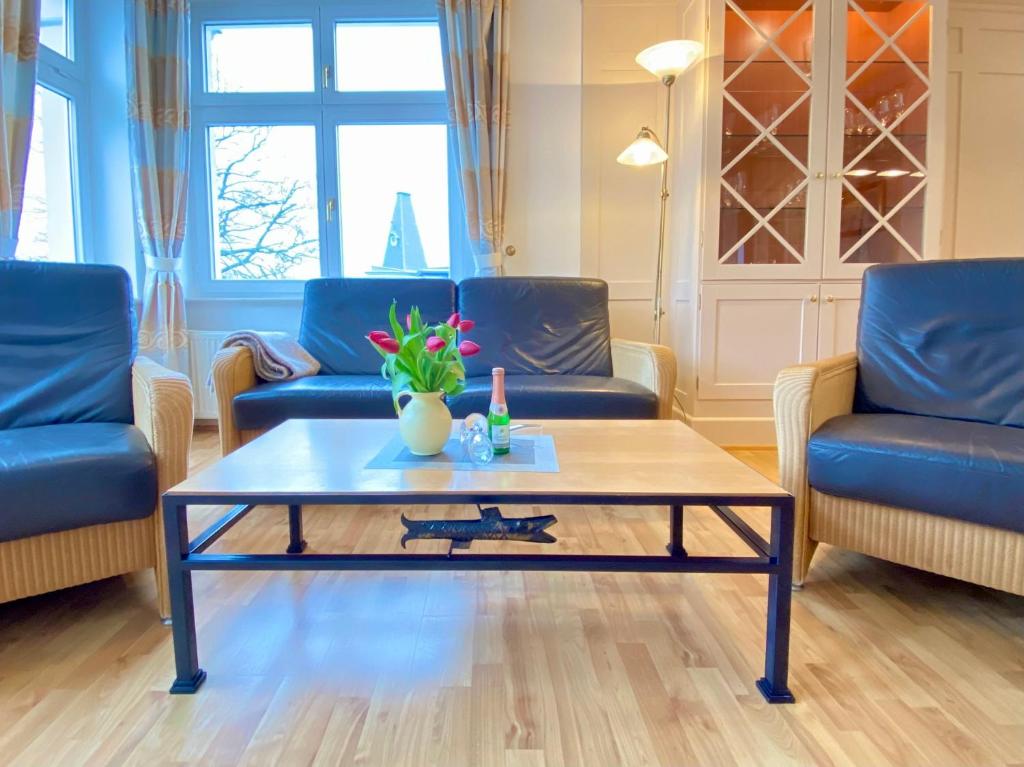 a living room with blue chairs and a coffee table at Villa Usedom App. 31 in Heringsdorf
