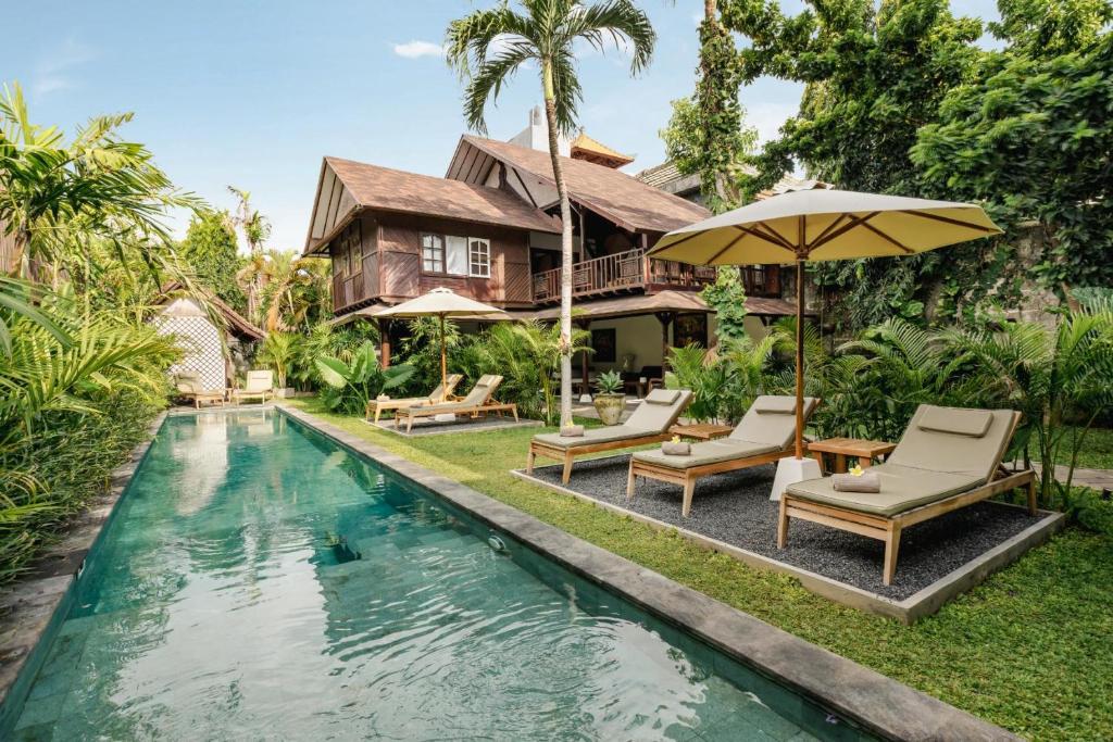 a villa with a pool in front of a house at Nativ Living Villa Legian 6BR Villa 16px Big Group Walk to 66 Beach in Seminyak