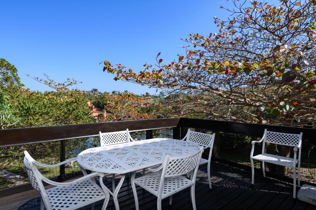 a table and chairs on a deck with a tree at San Lameer Villa 2845 - 3 Bedroom Classic - 6 pax - San Lameer Rental Agency in Southbroom