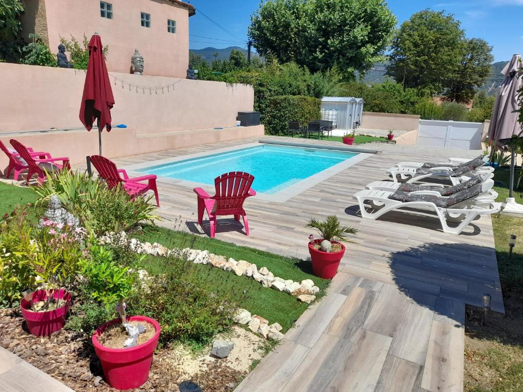 einen Hinterhof mit einem Pool mit Stühlen und einem Tisch in der Unterkunft Maison en Provence avec piscine in Château-Arnoux-Saint-Auban