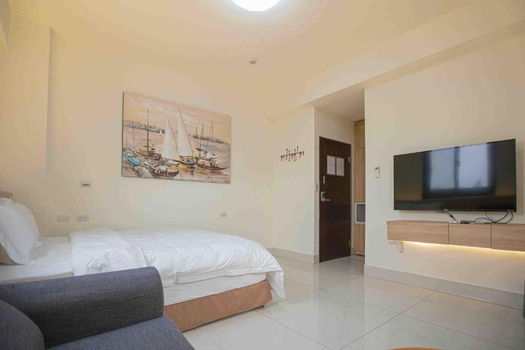 a bedroom with a bed and a flat screen tv at 里舍民宿 in Jincheng