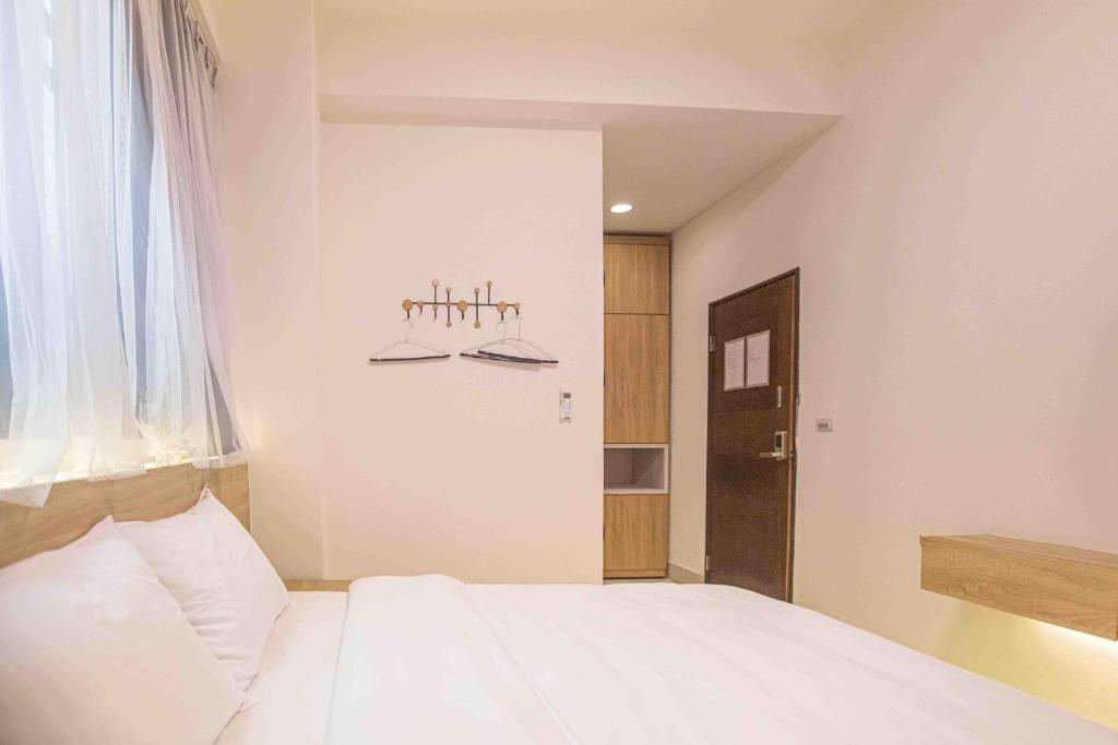 a bedroom with a white bed and a window at 里舍民宿 in Jincheng