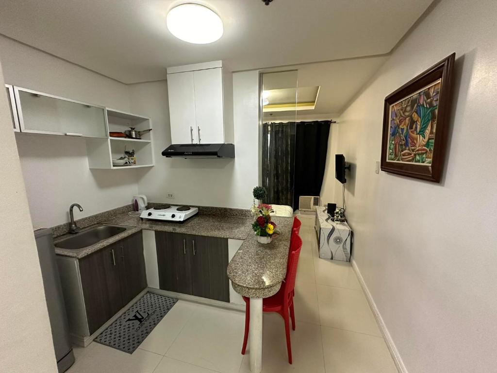 a small kitchen with a table and a sink at hotel in ermita manila birch tower in Manila