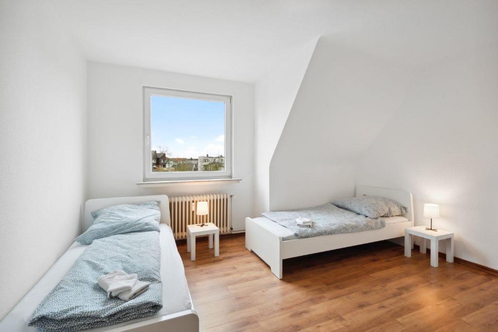 - une chambre avec 2 lits et une fenêtre dans l'établissement Nice Apartment in Bremerhaven, à Bremerhaven