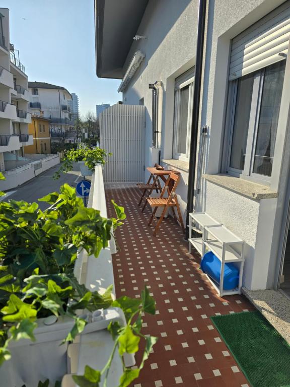un balcón con una mesa y algunas plantas. en APPARTAMENTO STELLA MARE en Lignano Sabbiadoro
