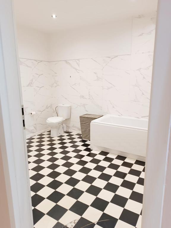 a bathroom with a black and white checkered floor at Studio Standard in Zielona Góra