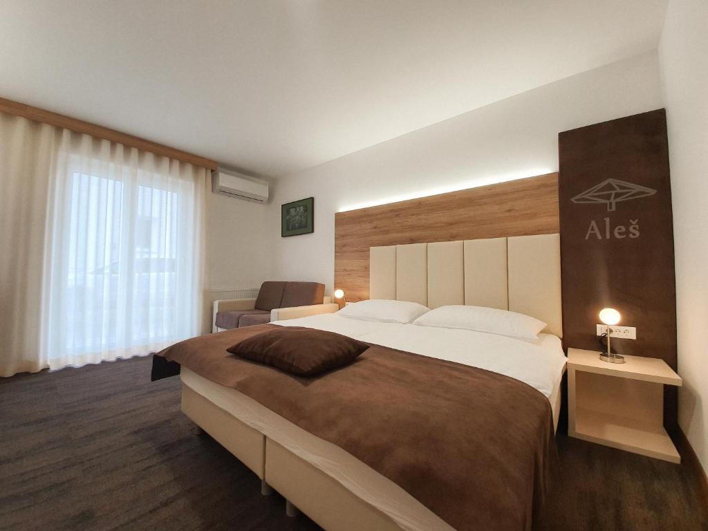 um quarto de hotel com uma cama grande e uma janela em Hiša Aleš em Kranj