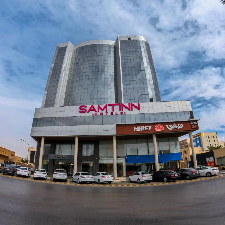 a large building with cars parked in front of it at SAMT INN HOTEL فندق سمت إن in Riyadh