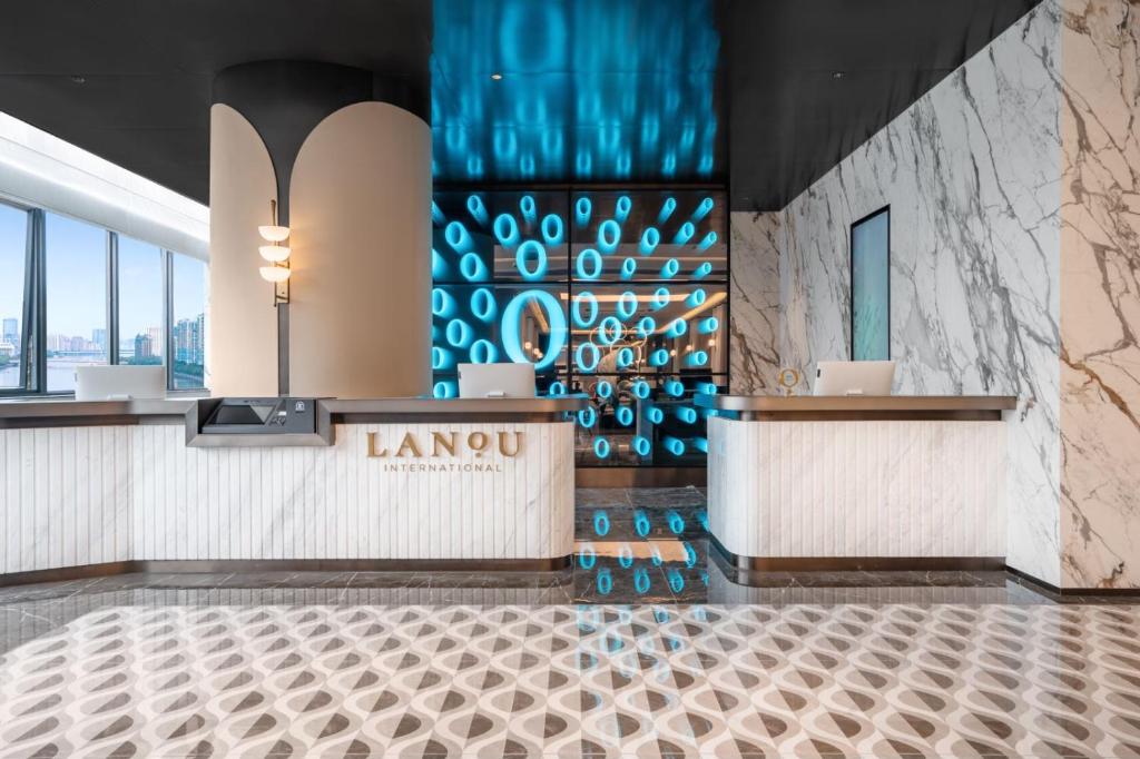 広州市にあるLanou Hotel Guangzhouのワインボトルの壁がある豪華なホテルのロビー