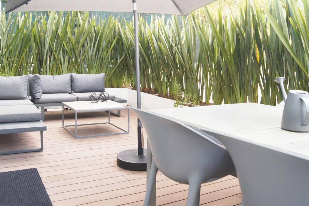 a patio with a table and a couch and an umbrella at Design Apartment with Amazing Private Terrace in Mexico City