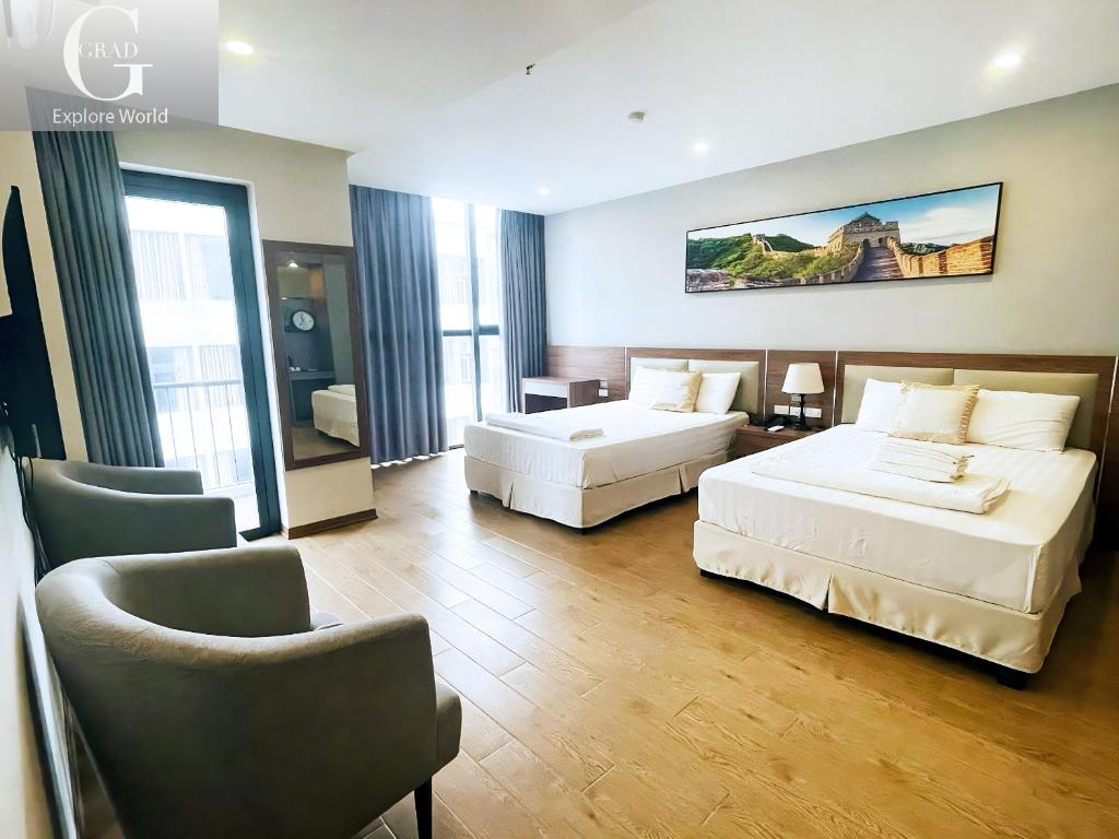 une chambre d'hôtel avec deux lits et une chaise dans l'établissement 1986's Hotel, à Dong Quan