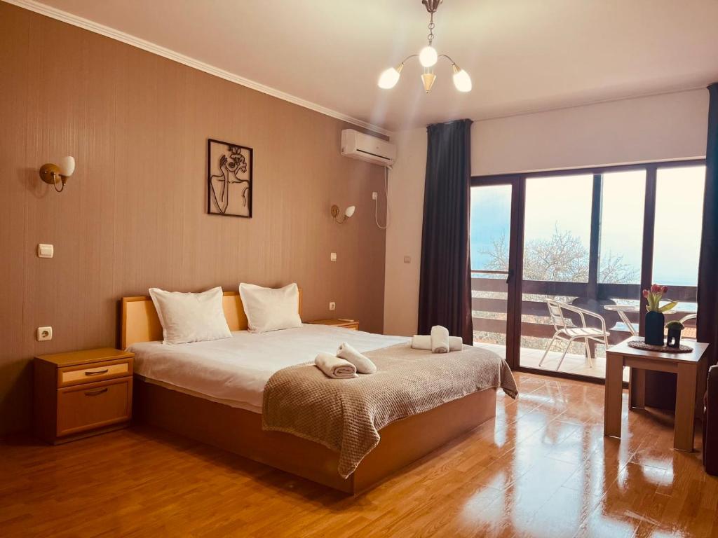 ein Schlafzimmer mit einem Bett und einem großen Fenster in der Unterkunft Парк хотел Боили-Кирека in Kaspichan