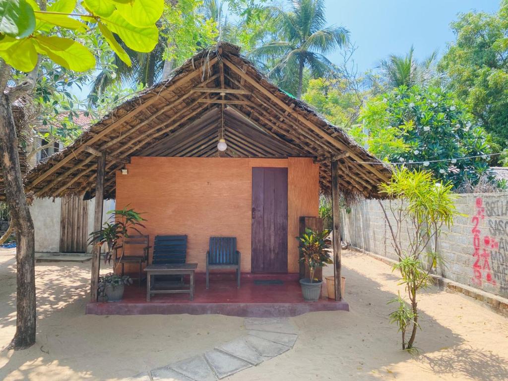 Casa pequeña con 2 sillas y mesa en Rainbow Village Cabanas, en Arugam Bay