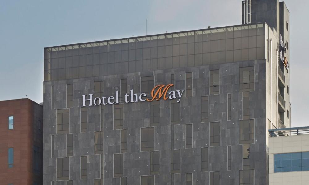 un hôtel indiquant la direction sur le côté d'un bâtiment dans l'établissement Hotel The May, à Namyangju